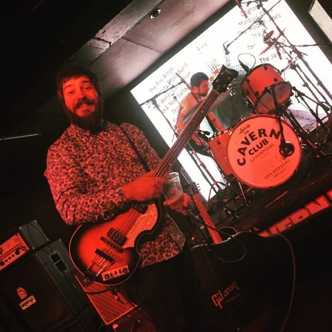 Playing bass on stage at the Cavern Club, Liverpool